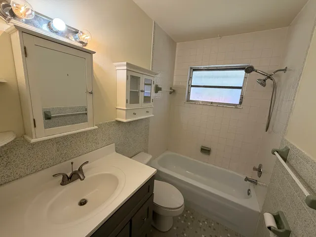 a bathroom with a sink mirror toilet and bathtub