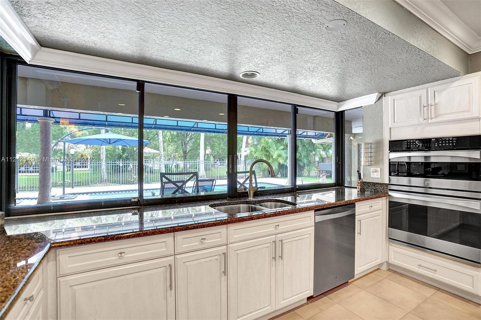 7360 Southwest 16th Street Plantation, FL 33317 - Photo 41 of 70 a kitchen with granite countertop a large window and a sink