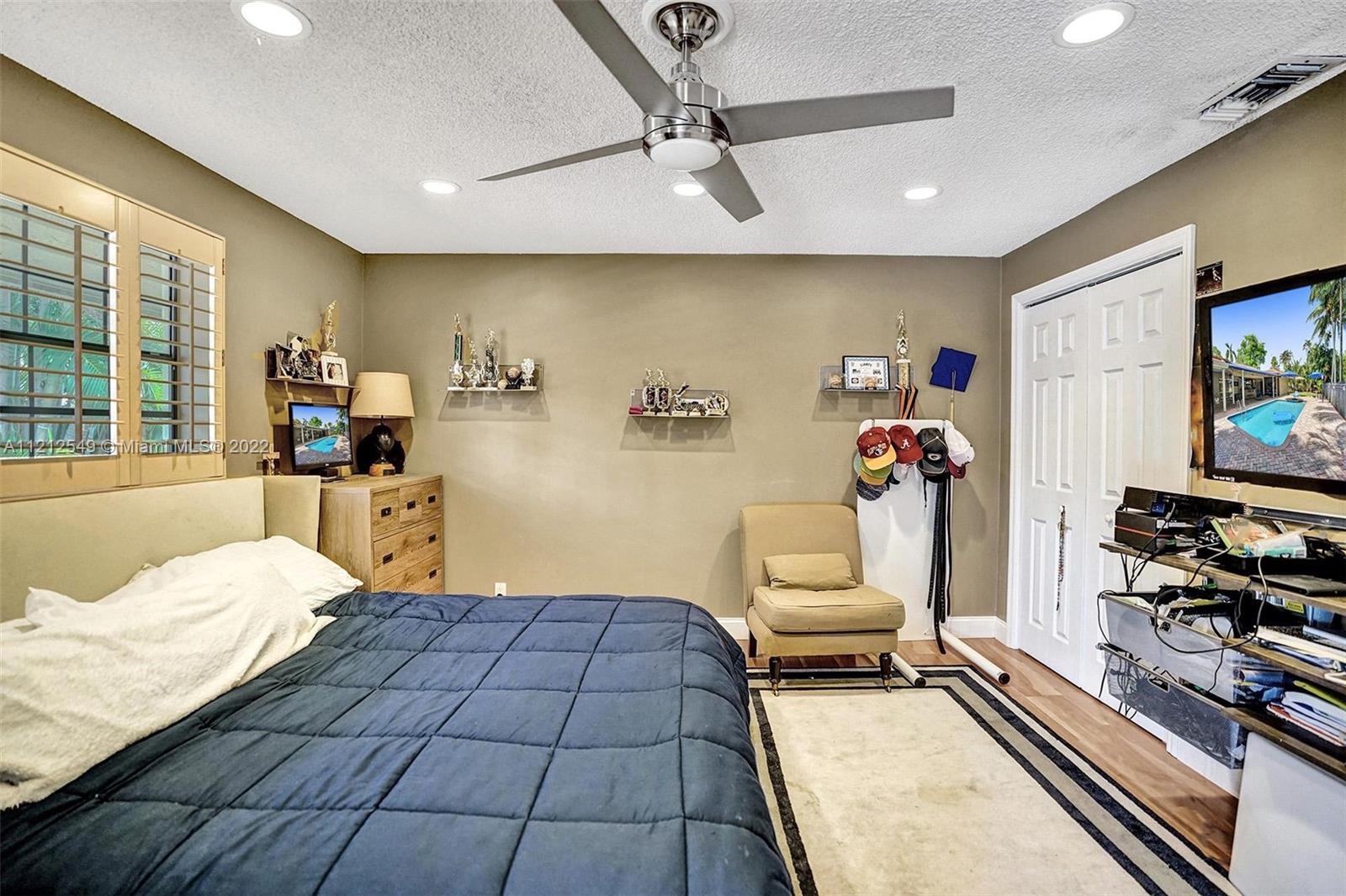 7360 Southwest 16th Street Plantation, FL 33317 - Photo 45 of 70 a bedroom with a bed and a flat tv screen on dresser