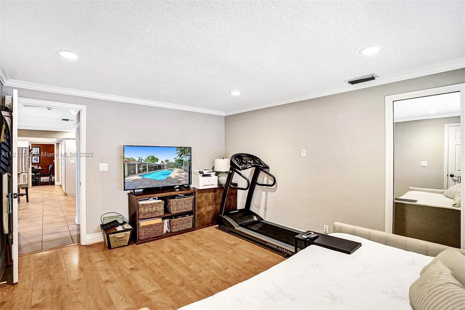 7360 Southwest 16th Street Plantation, FL 33317 - Photo 52 of 70 a bedroom with a bed and wooden floor