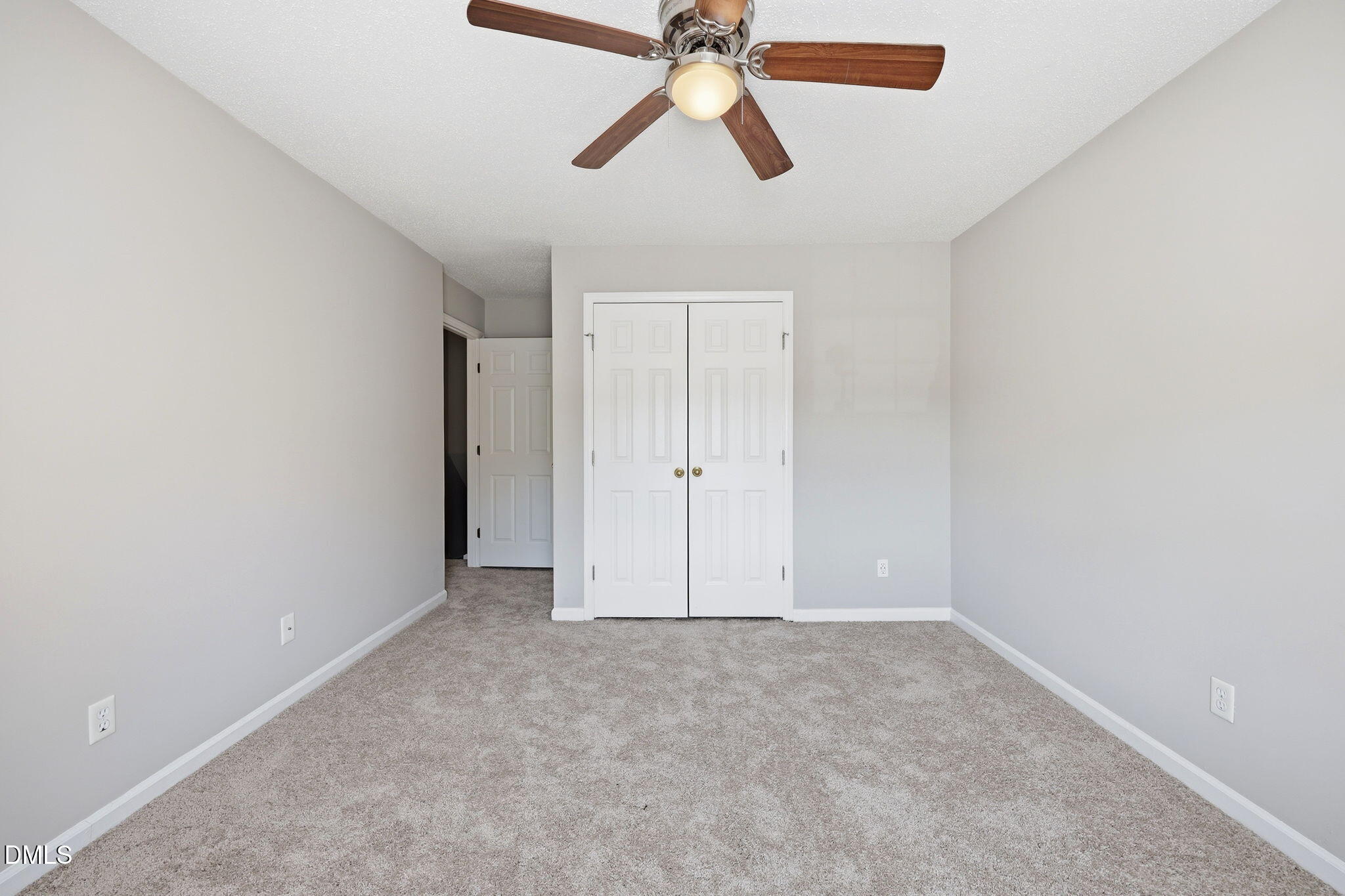 145 Jones Franklin Road, Unit D Raleigh, NC 27606 - Photo 15 of 23 an empty room with closet and a chandelier fan