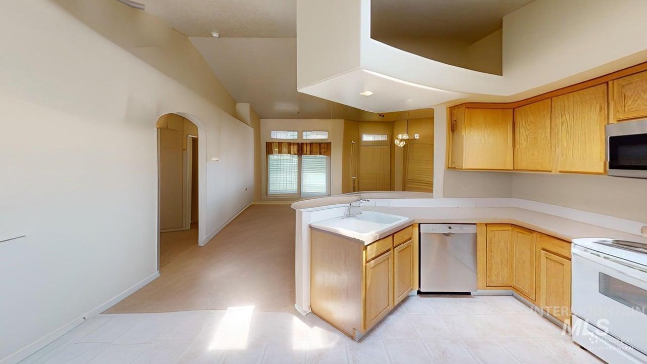 16609 Old Friendship Way Caldwell, ID 83607 - Photo 15 of 23 Vaulted ceiling with an integrated display ledge, sliding glass patio door, and a built-in pet door