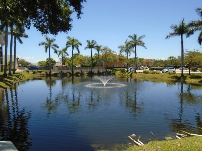 6195 Rock Island Road, Unit 402 Tamarac, FL 33319 - Photo 22 of 23 a view of water with boats and palm trees