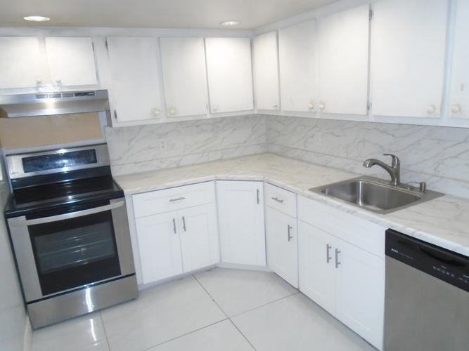 6195 Rock Island Road, Unit 402 Tamarac, FL 33319 - Photo 3 of 23 a kitchen with white cabinets appliances and sink