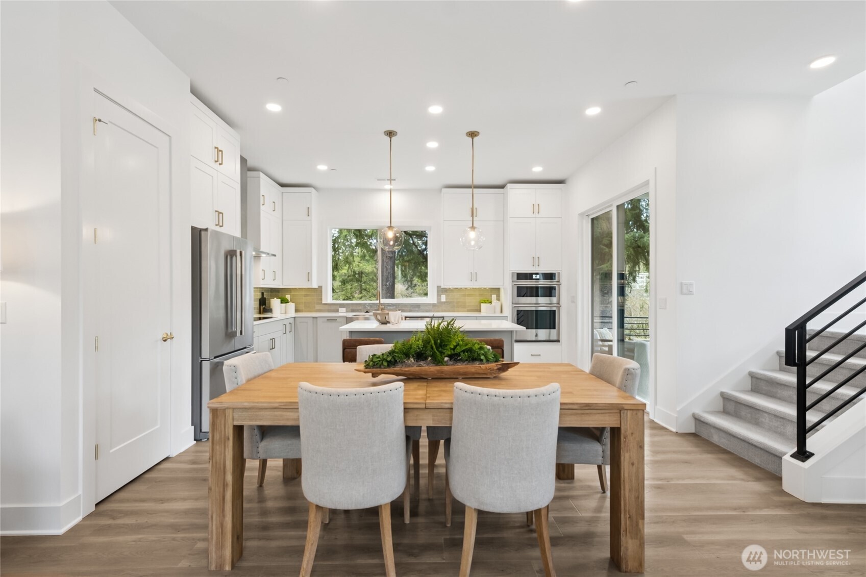 18809 99th Place Northeast, Unit C Bothell, WA 98011 - Photo 14 of 35 a kitchen with a dining table chairs refrigerator and stove