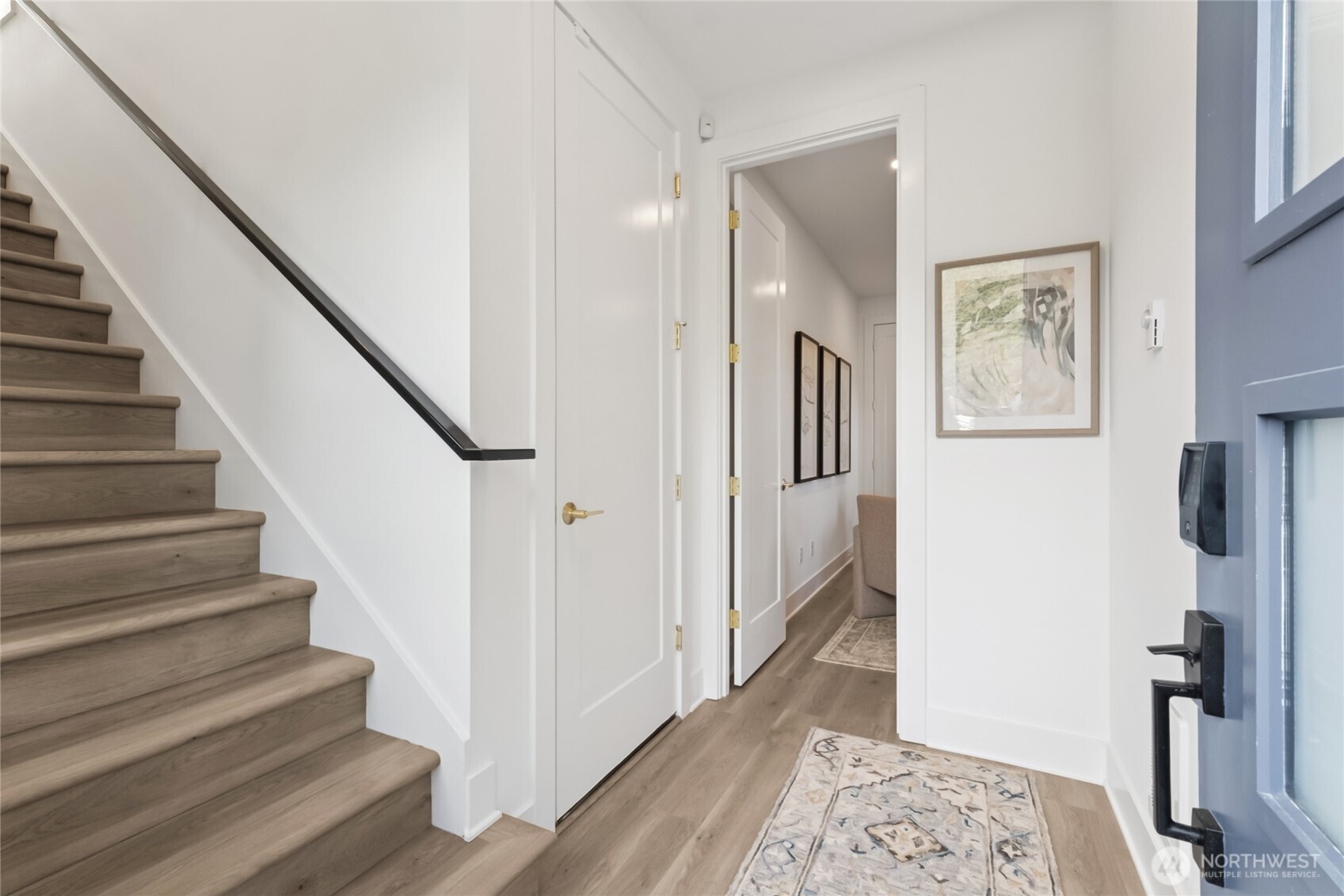 18809 99th Place Northeast, Unit C Bothell, WA 98011 - Photo 3 of 35 a view of a hallway with wooden floor and staircase
