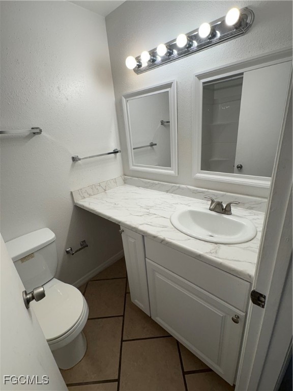2855 Winkler Avenue, Unit 113 Fort Myers, FL 33916 - Photo 13 of 24 a bathroom with a granite countertop sink toilet a mirror and vanity