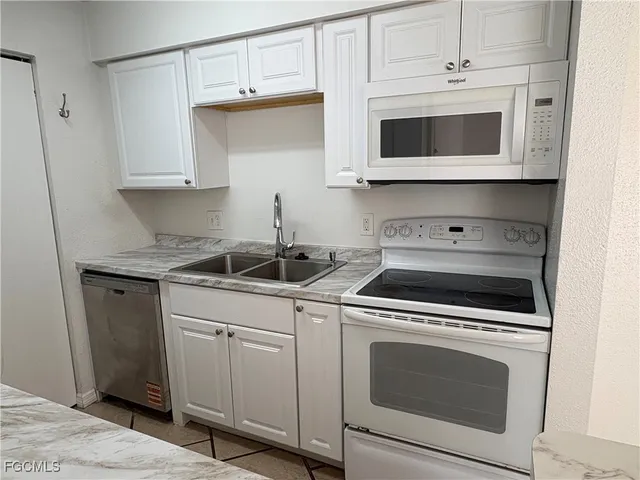 a kitchen with white cabinets stainless steel appliances and sink
