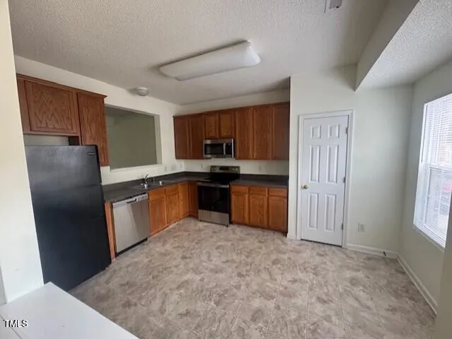 a kitchen with stainless steel appliances granite countertop a refrigerator and a sink