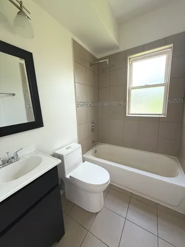 a bathroom with a bathtub a sink a toilet and a mirror