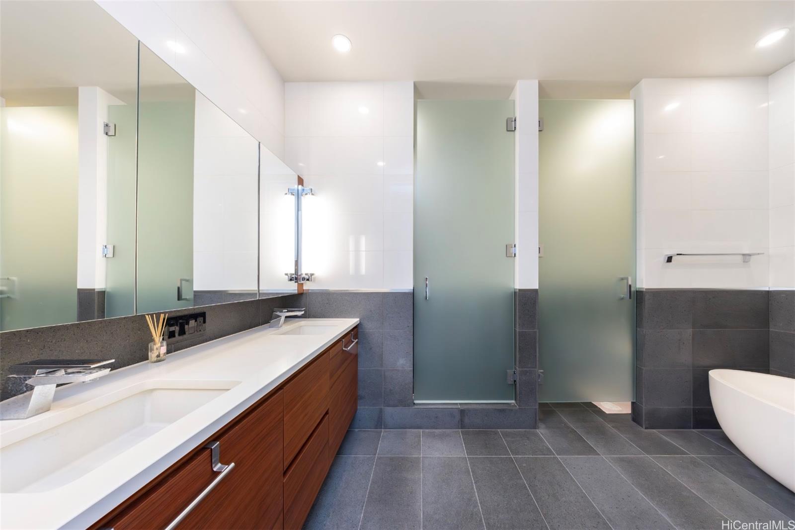 1108 Auahi Street, Unit 3300 Honolulu, HI 96814 - Photo 15 of 25 a bathroom with a double vanity sink a mirror and a shower