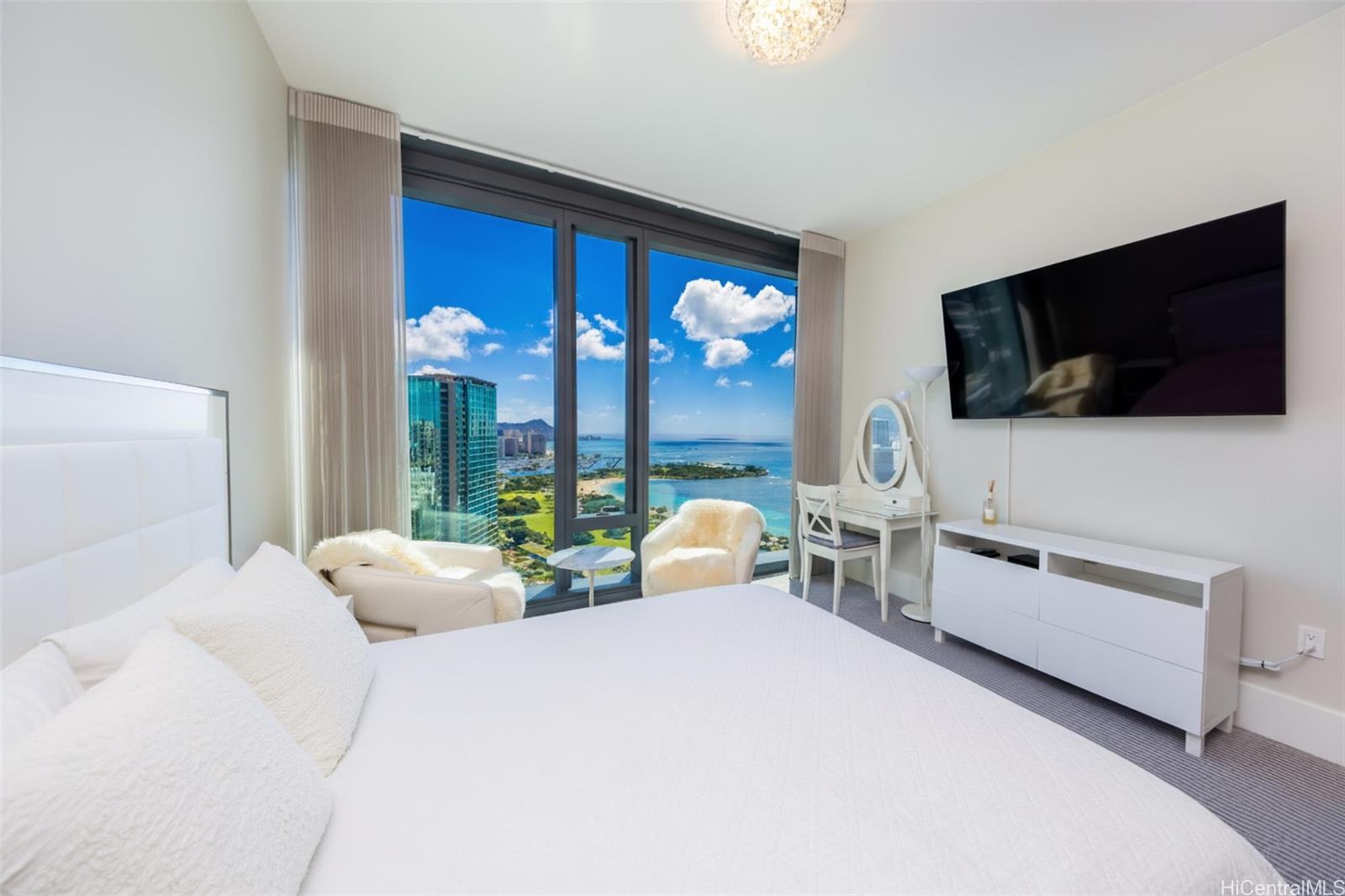 1108 Auahi Street, Unit 3300 Honolulu, HI 96814 - Photo 18 of 25 a bedroom with a bed and a flat screen tv