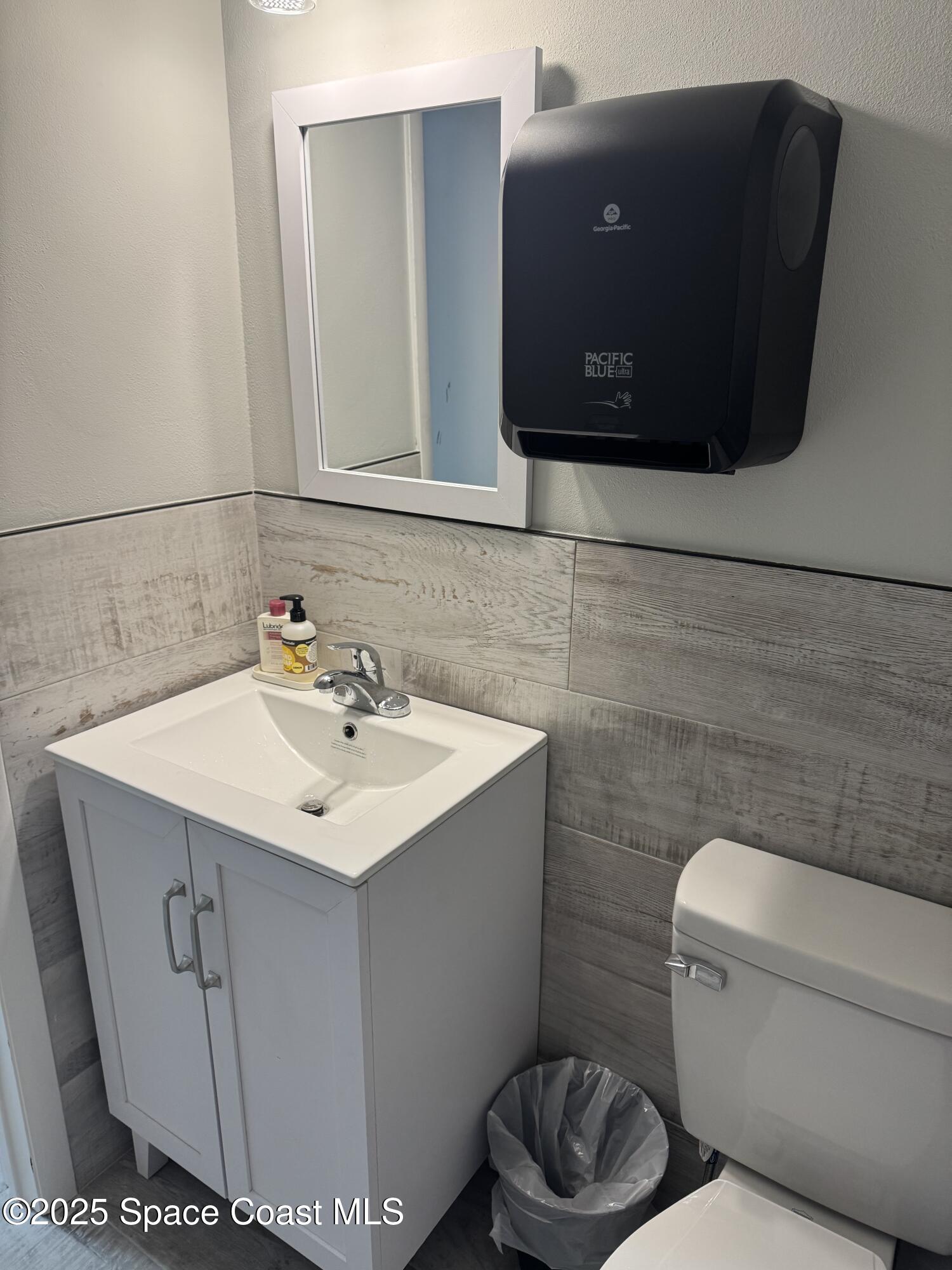 700 North Wickham Road, Unit 101 Melbourne, FL 32935 - Photo 6 of 12 a bathroom with a sink toilet and mirror
