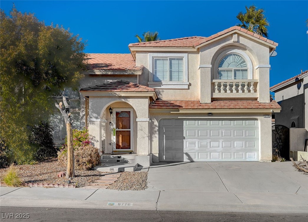Mediterranean / spanish home with a tiled roof, concrete driveway, a garage, and stucco siding