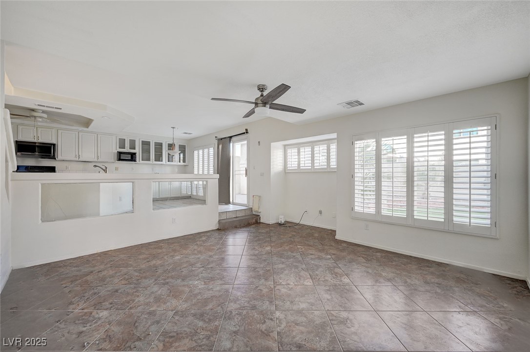 8776 Country View Avenue Las Vegas, NV 89129 - Photo 16 of 43 Unfurnished living room featuring a ceiling fan and baseboards