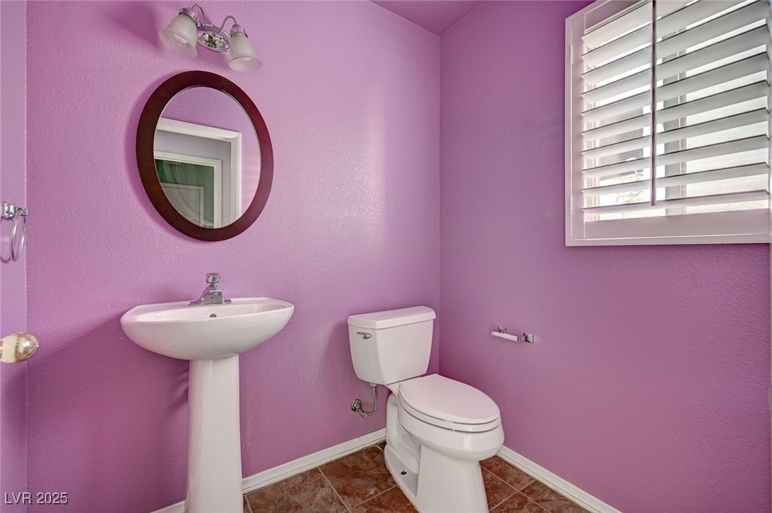 8776 Country View Avenue Las Vegas, NV 89129 - Photo 18 of 43 Half bath featuring toilet and dark tile patterned floors