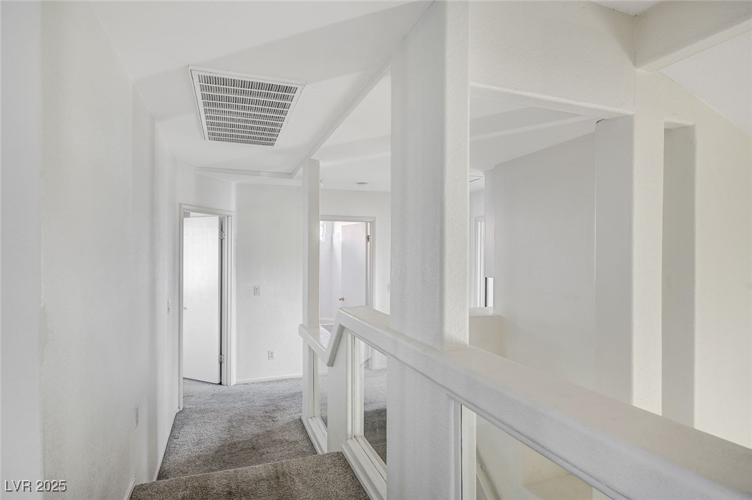 8776 Country View Avenue Las Vegas, NV 89129 - Photo 27 of 43 Corridor featuring light carpet and an upstairs landing