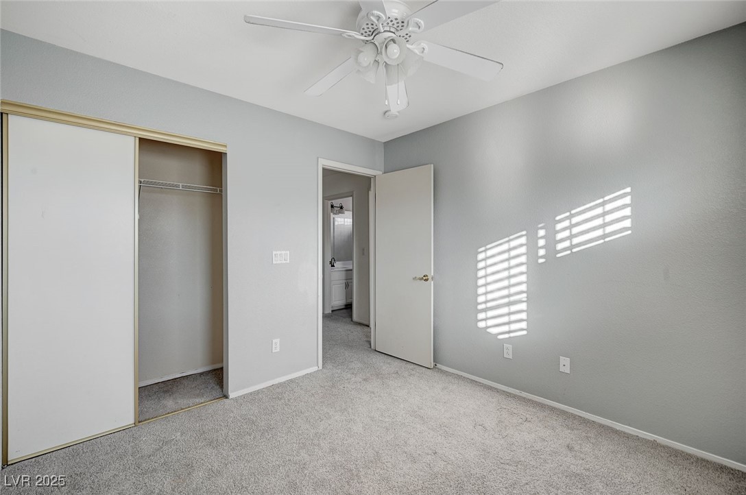 8776 Country View Avenue Las Vegas, NV 89129 - Photo 34 of 43 Unfurnished bedroom with light carpet, a closet, and a ceiling fan