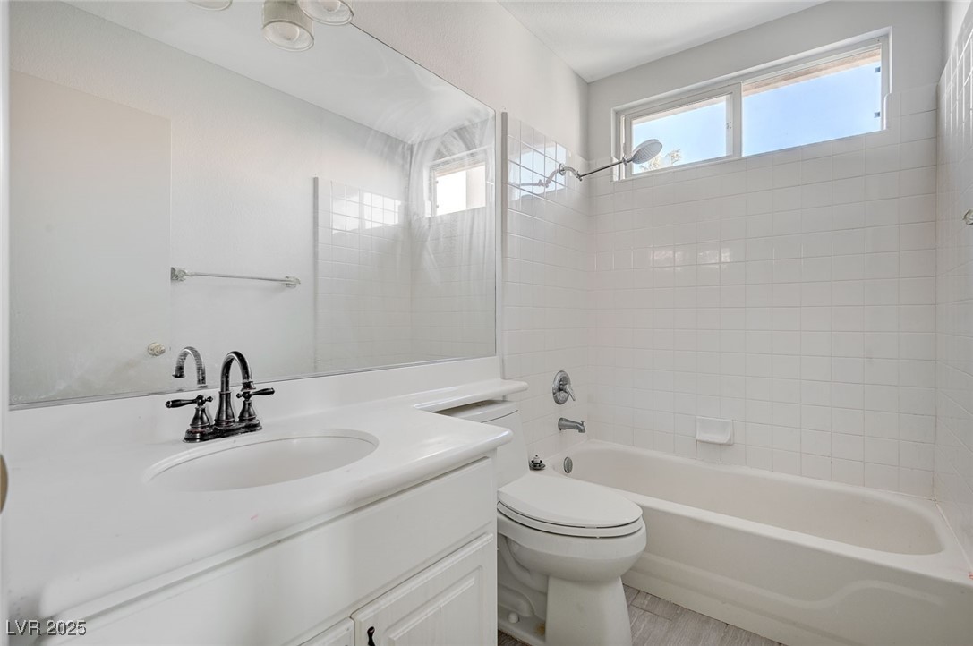 8776 Country View Avenue Las Vegas, NV 89129 - Photo 35 of 43 Bathroom with bathtub / shower combination, vanity, and light wood-type flooring