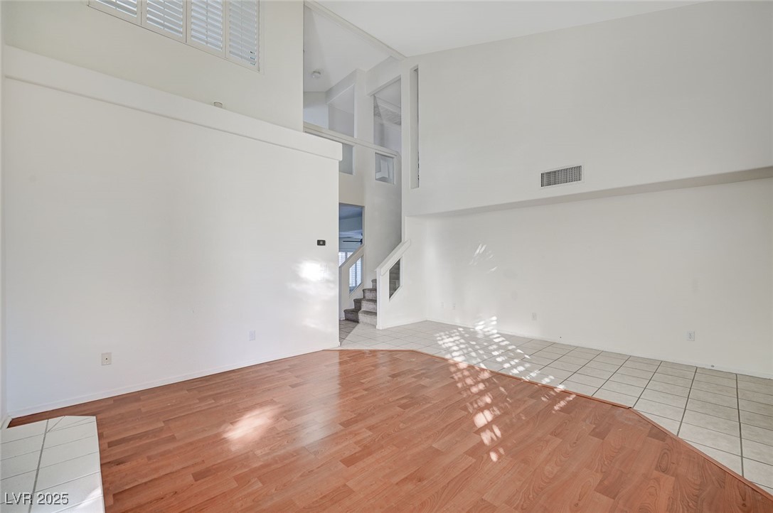 8776 Country View Avenue Las Vegas, NV 89129 - Photo 5 of 43 Unfurnished living room with a high ceiling, light wood-type flooring, and stairs