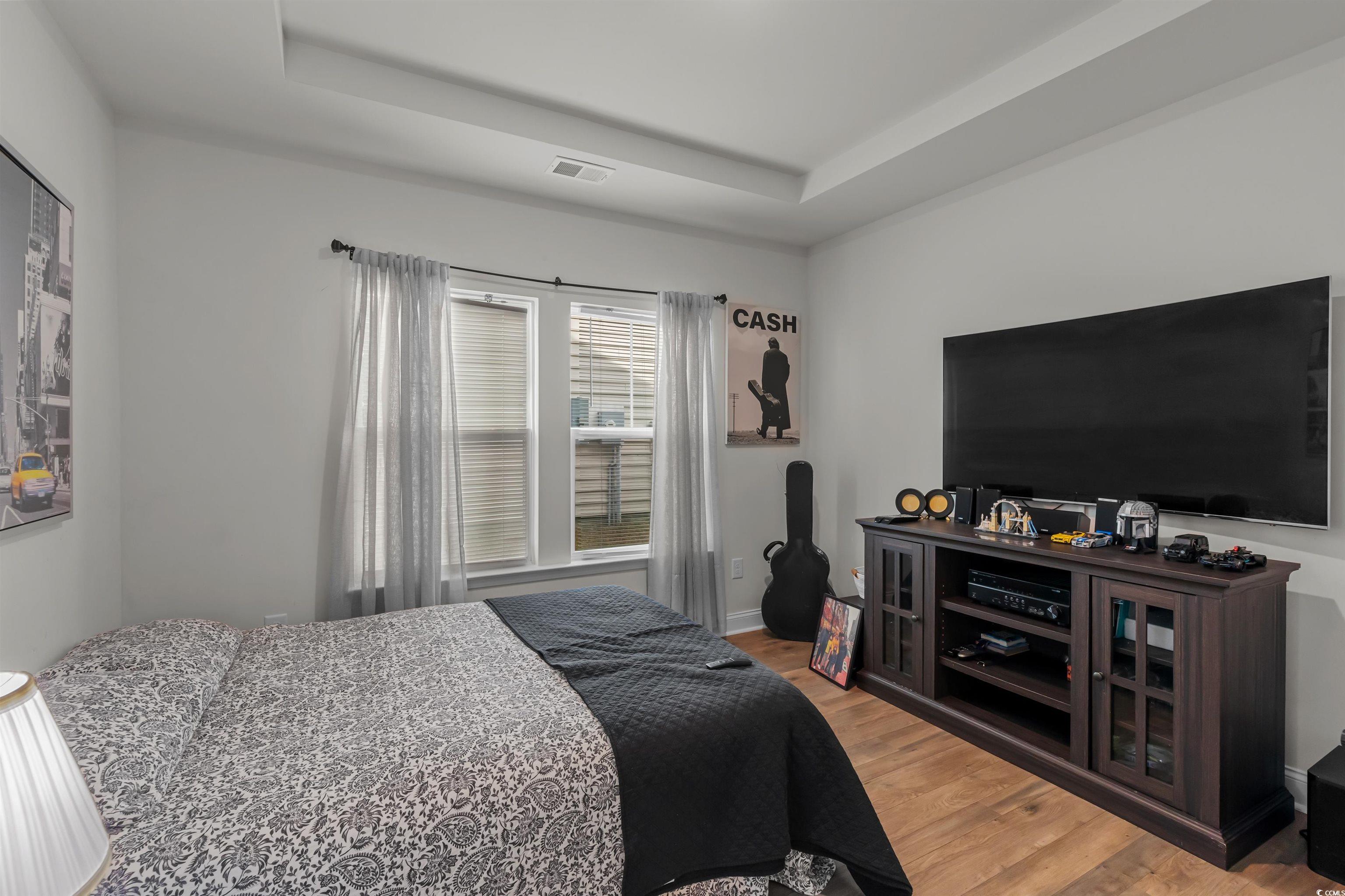 1176 HARBISON Circle Myrtle Beach, SC 29579 - Photo 12 of 40 Bedroom with a raised ceiling, wood finished floors, and visible vents