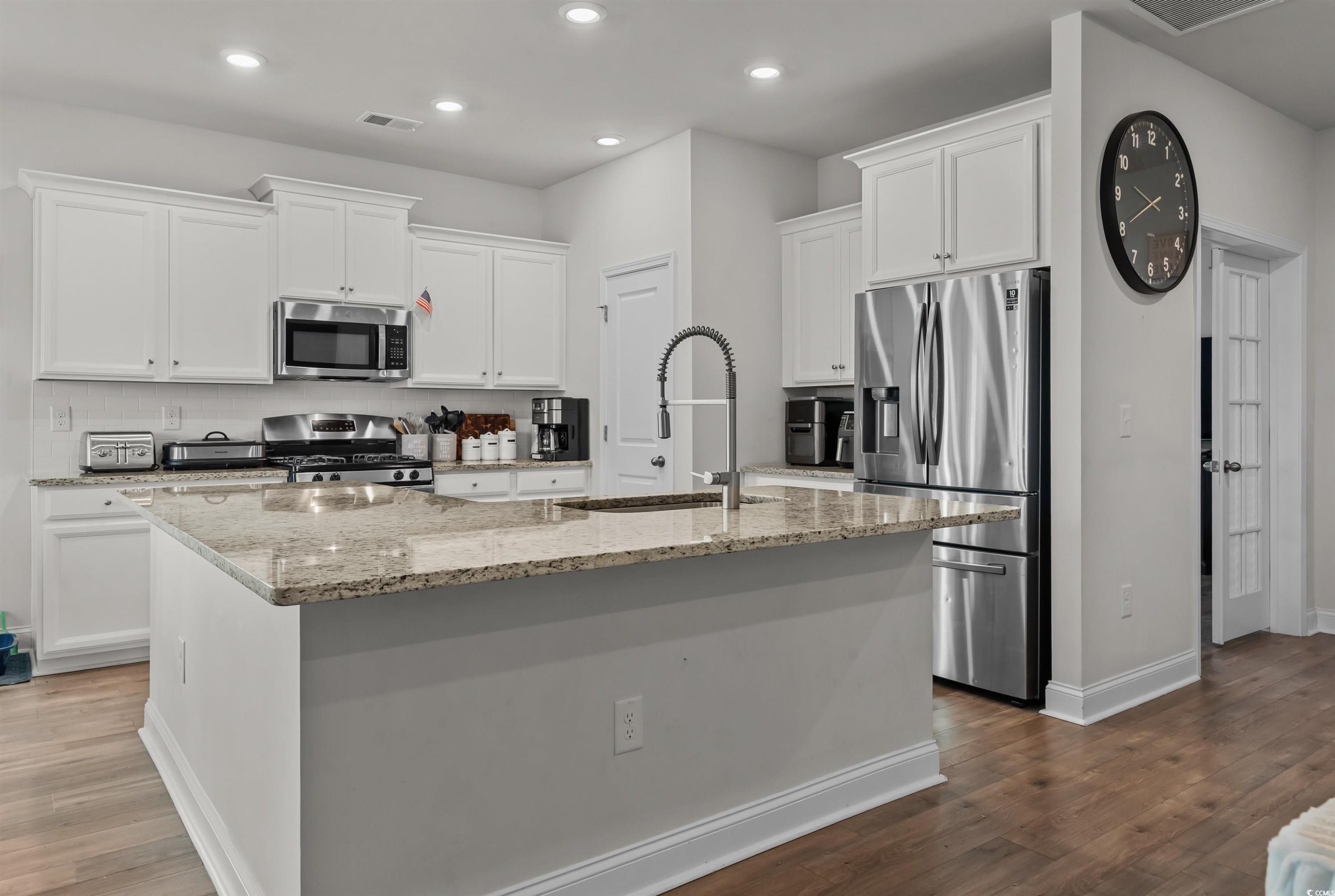 1176 HARBISON Circle Myrtle Beach, SC 29579 - Photo 16 of 40 Kitchen featuring a center island with sink, a sink, wood finished floors, and appliances with stainless steel finishes