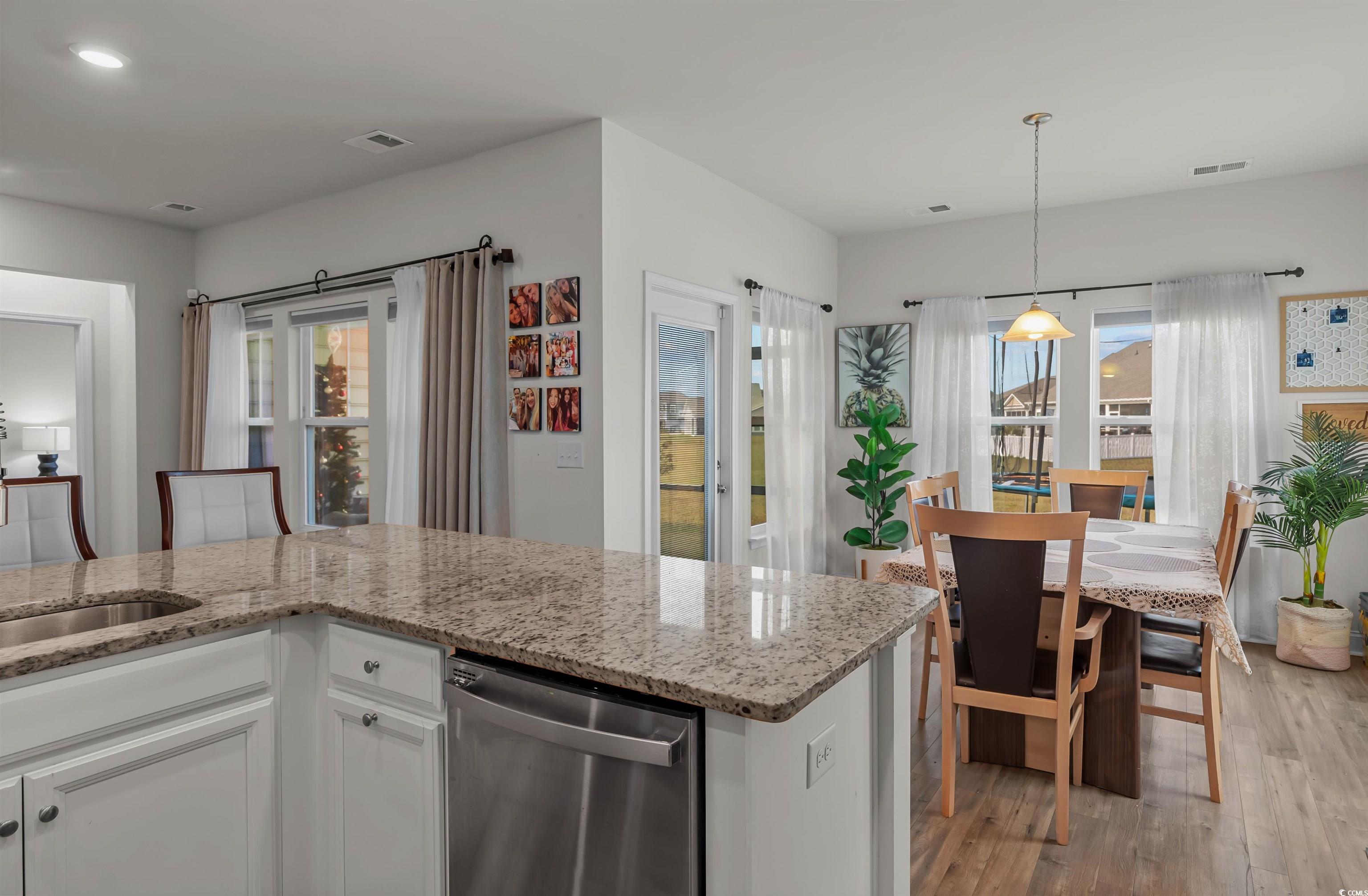 1176 HARBISON Circle Myrtle Beach, SC 29579 - Photo 18 of 40 Kitchen with white cabinets, light stone counters, light wood-type flooring, and dishwasher