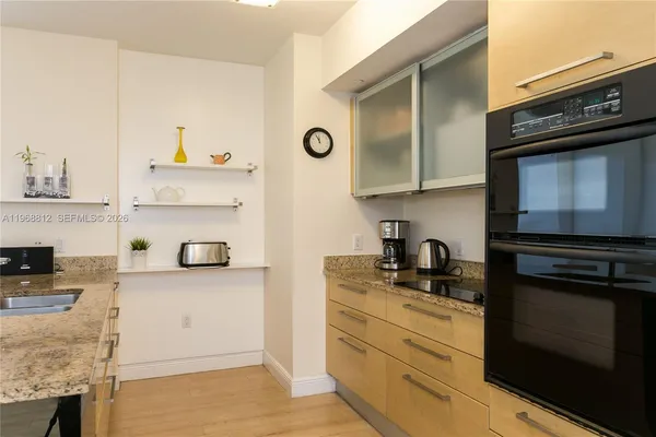 a kitchen with granite countertop cabinets stainless steel appliances and a counter space