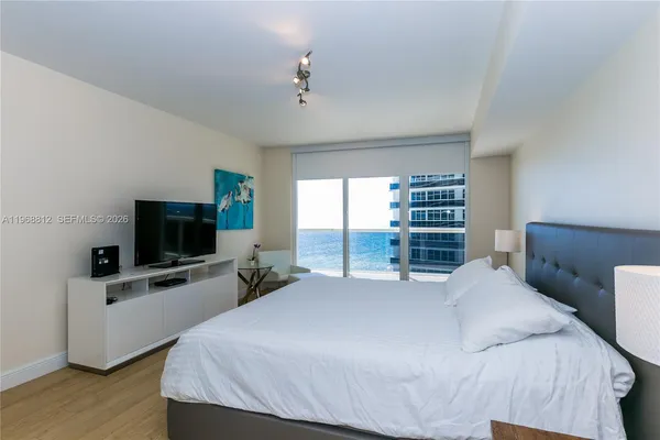 a bedroom with a large bed and a flat screen tv