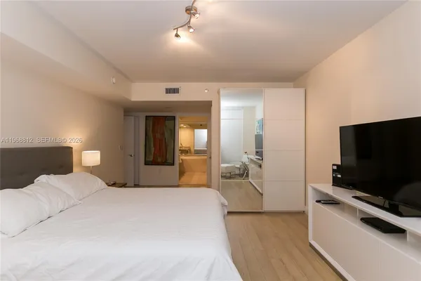 a bedroom with a bed and a flat screen tv