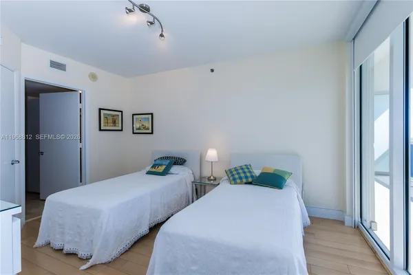 a bedroom with two beds and wooden floor