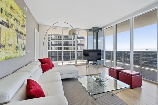 a living room with furniture a flat screen tv and a large window