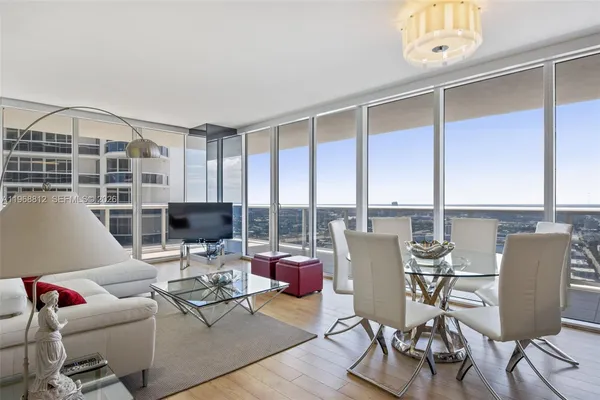 a living room with furniture and floor to ceiling windows