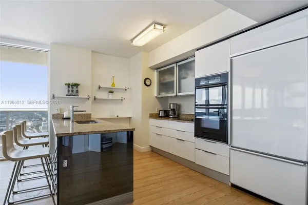 a large kitchen with kitchen island granite countertop lots of counter top space and stainless steel appliances
