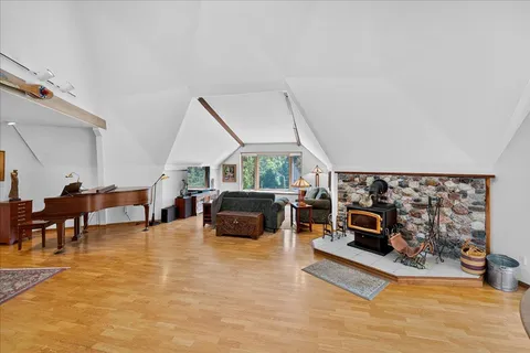 a living room with furniture stove and a wooden floor