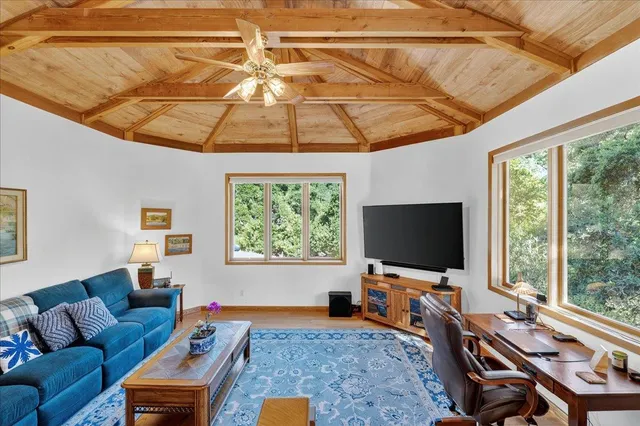 a view of a street with flower plants and wooden fence