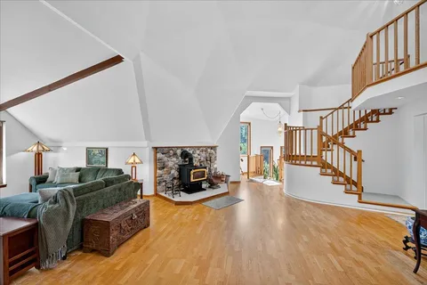 an aerial view of residential house with outdoor space and trees all around