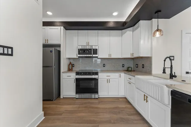 a kitchen with stainless steel appliances granite countertop a sink and a stove