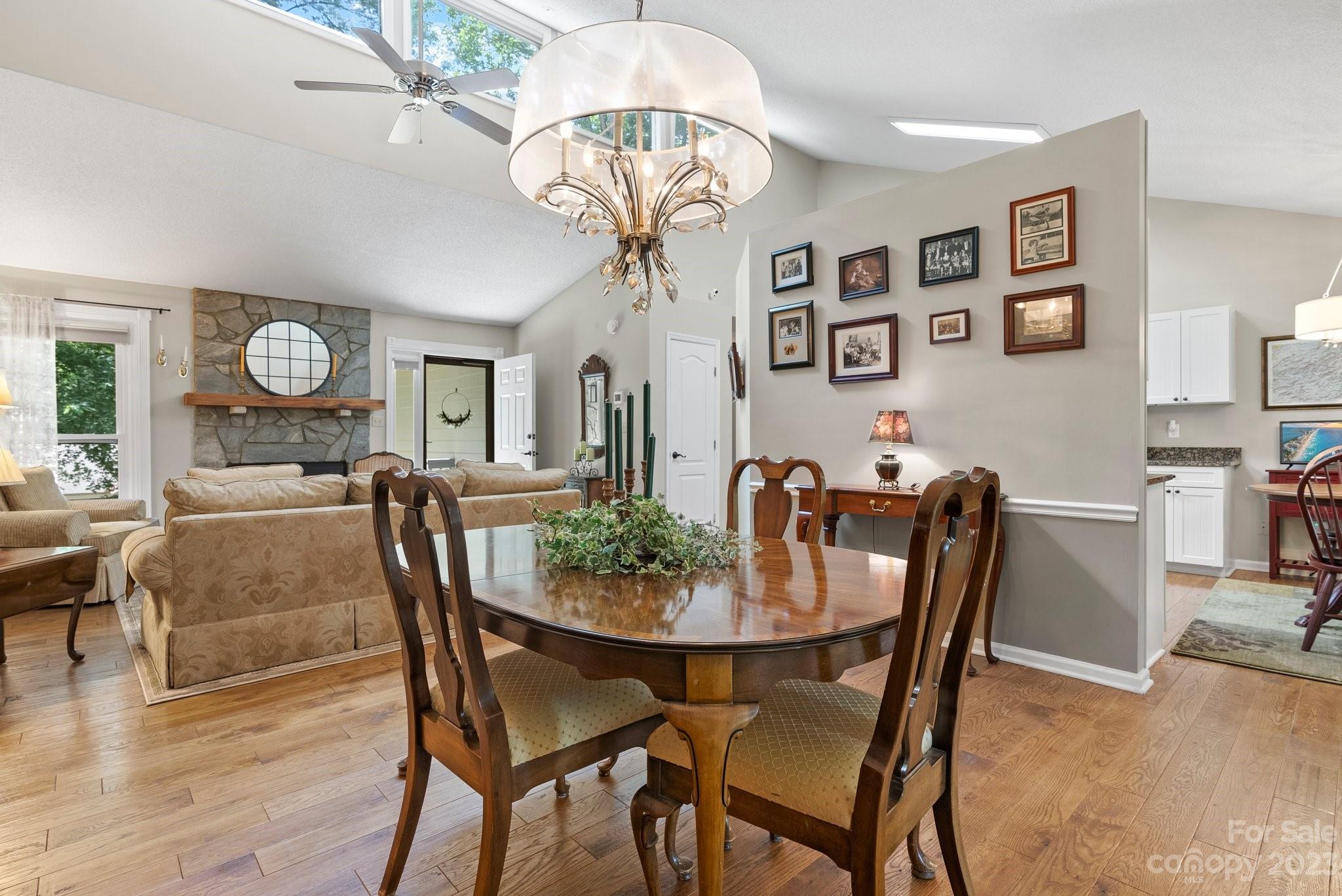 6 Holly Ridge Court Arden, NC 28704 - Photo 7 of 27 a dining room with wooden floor a chandelier a wooden table and chairs