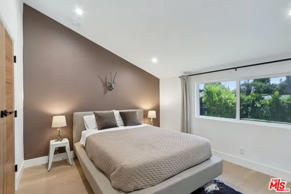 a bedroom with a large bed and a large window