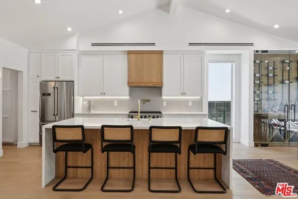 a kitchen with a table chairs refrigerator and cabinets