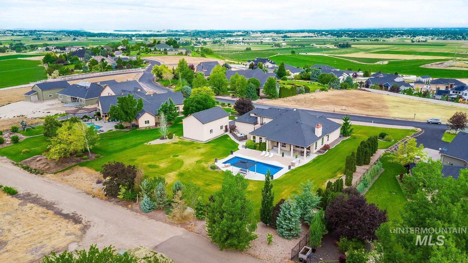 8077 Star Pass Ridge Road Nampa, ID 83686 - Photo 37 of 37 Expansive property featuring a large inground pool, spacious patio area, and extensive manicured landscaping