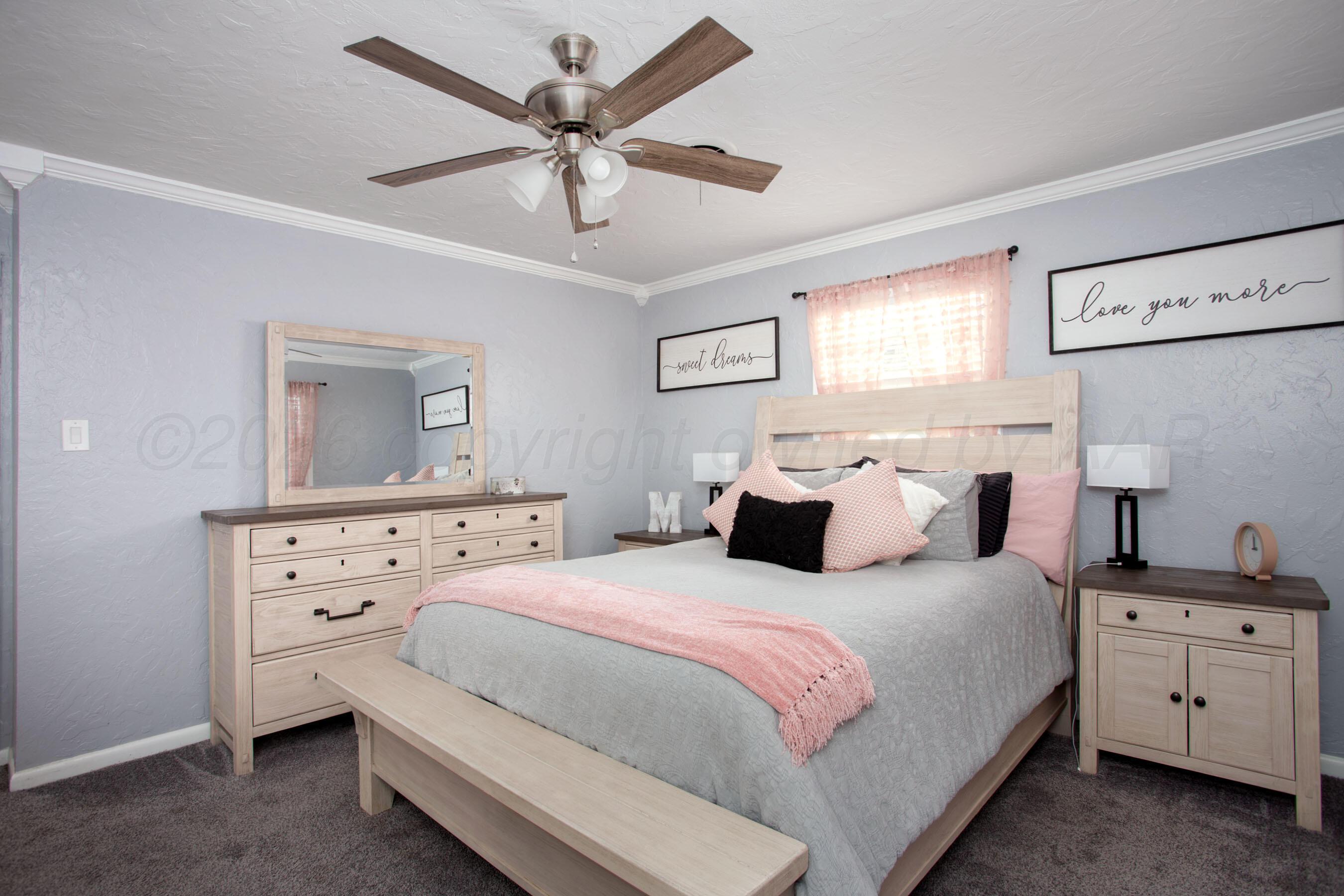 5206 George Terrace Amarillo, TX 79106 - Photo 8 of 24 a bedroom with a bed and a chandelier