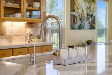 a kitchen with stainless steel appliances granite countertop a sink a stove and a refrigerator