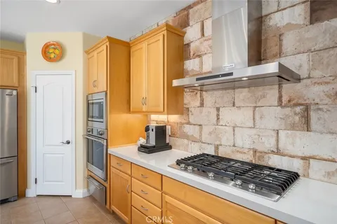 a kitchen with stainless steel appliances granite countertop a sink a stove and a wooden floors