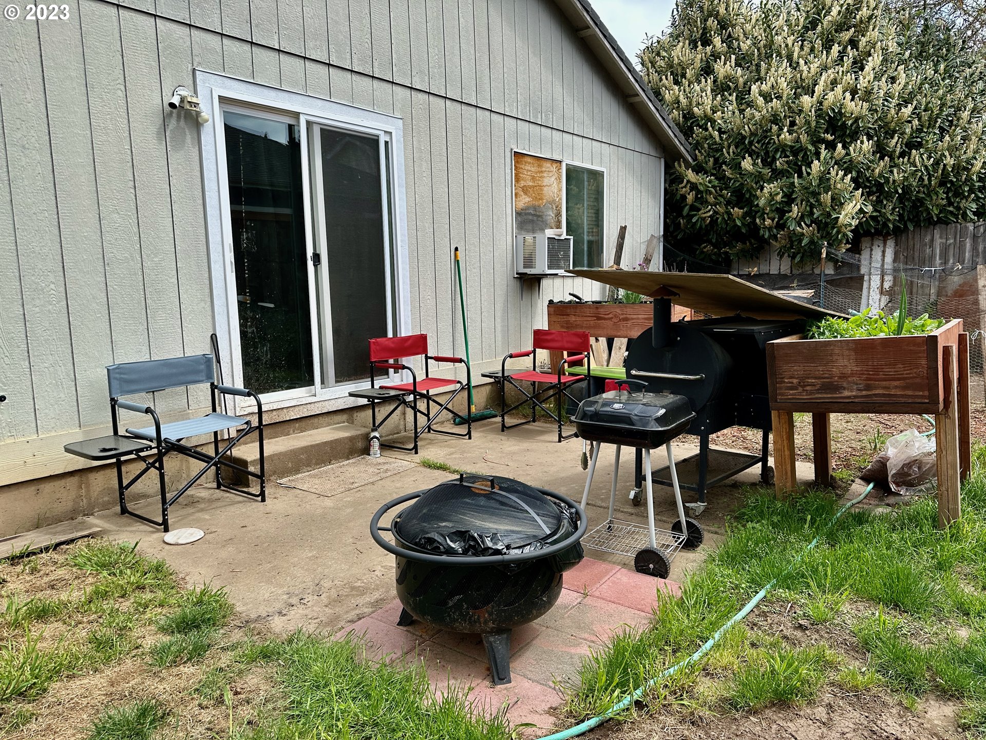 549 Nicholas Drive Springfield, OR 97477 - Photo 3 of 9 a view of a backyard with table and chairs potted plants and a large tree