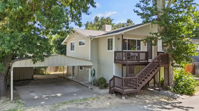a view of a house with a yard and a wooden deck