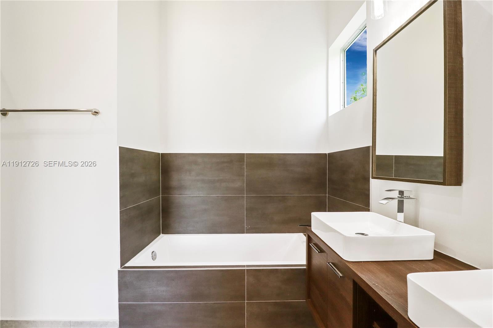 3461 Southwest 25th Street, Unit A Miami, FL 33133 - Photo 13 of 27 a bathroom with a sink and a mirror