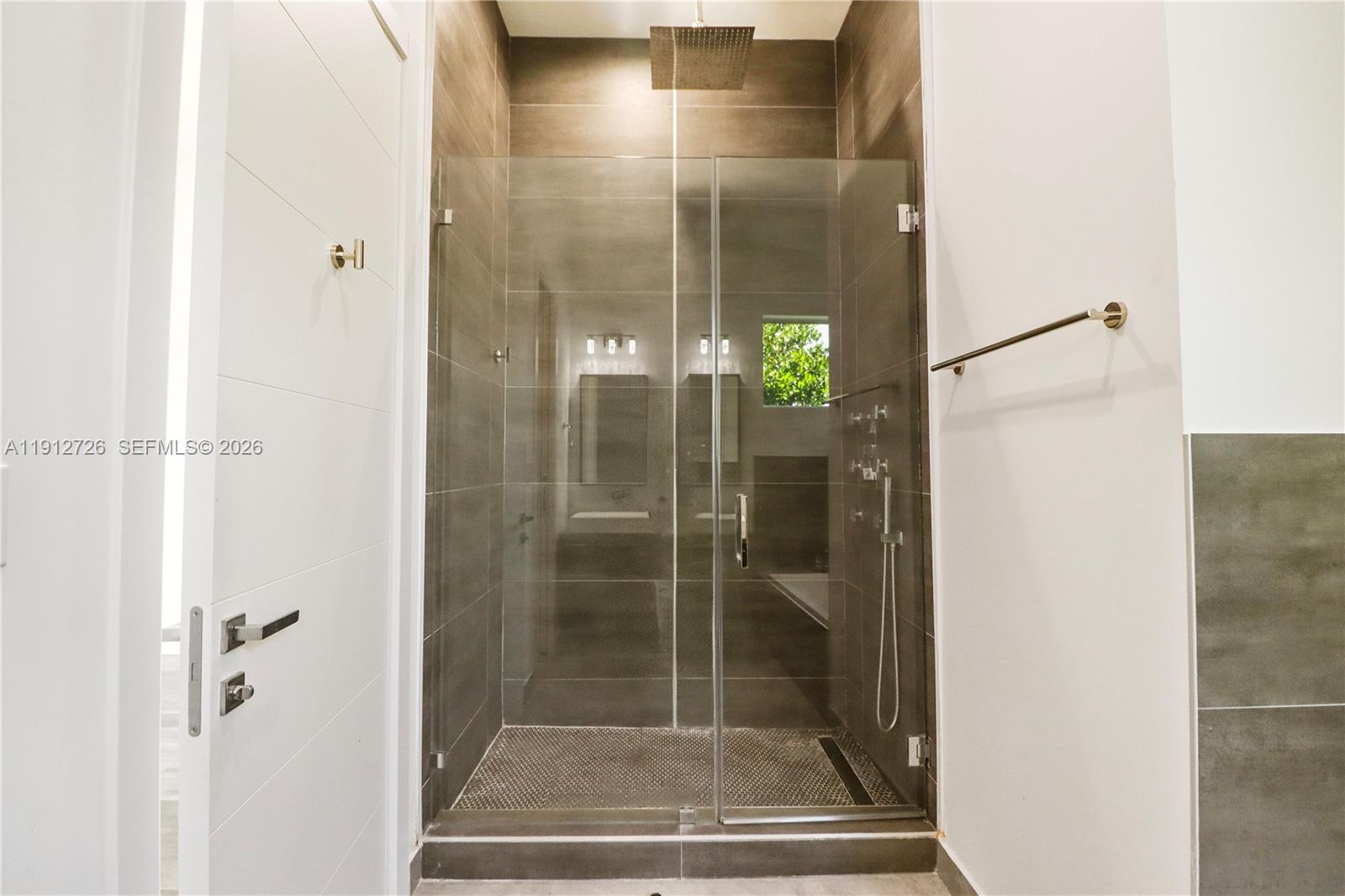 3461 Southwest 25th Street, Unit A Miami, FL 33133 - Photo 14 of 27 a bathroom with a glass shower door