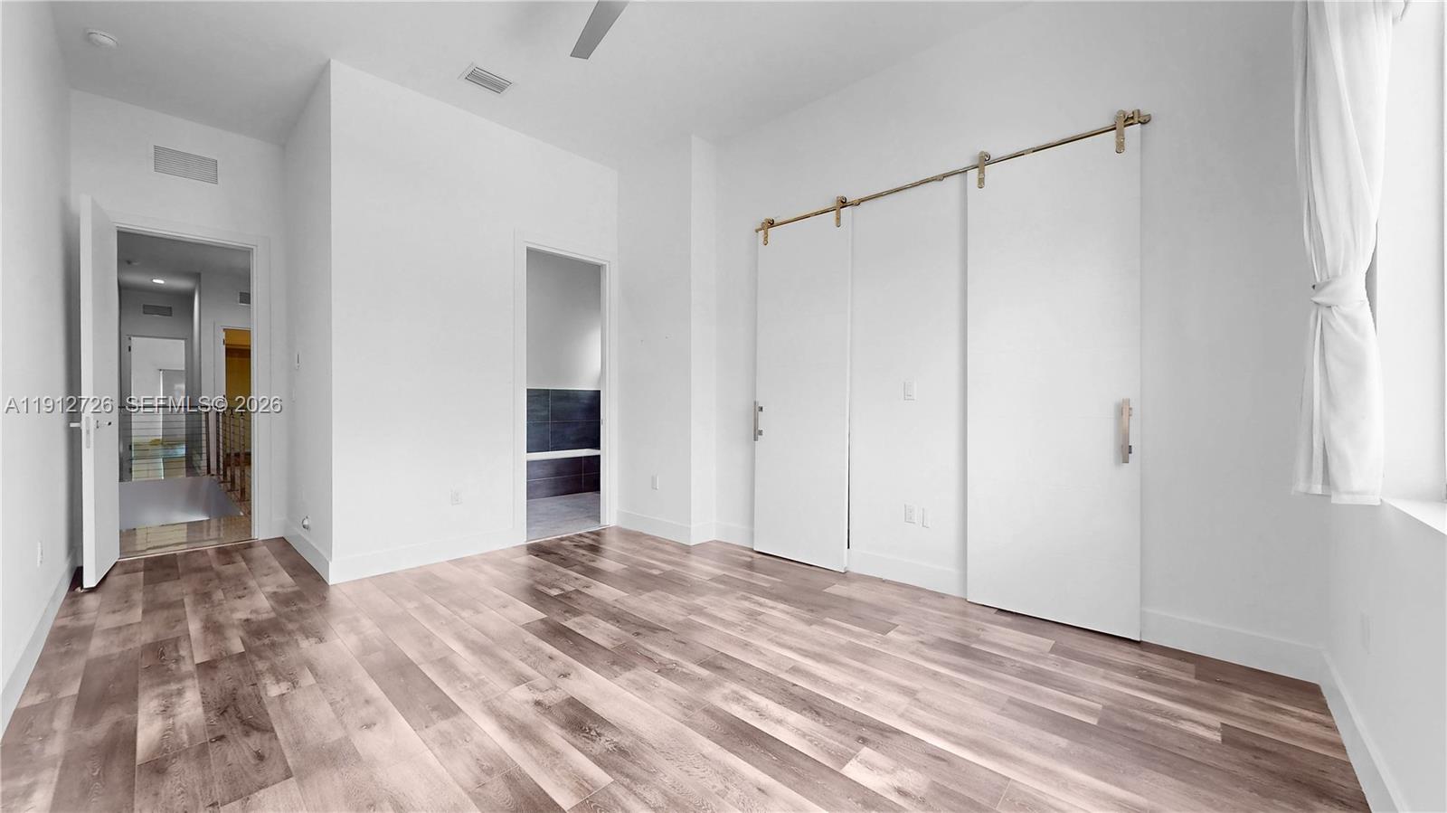 3461 Southwest 25th Street, Unit A Miami, FL 33133 - Photo 16 of 27 a view of a room with a ceiling fan and wooden floor